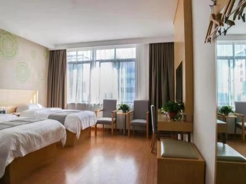 a hotel room with two beds and a desk at GreenTree Inn Jiangxi Yingtan Xinjiang Area Government No. 1 Middle Business Hotel in Yingtan