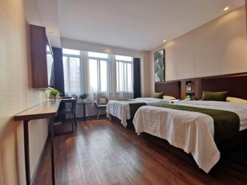 Postel nebo postele na pokoji v ubytování GreenTree Inn Anhui Lu’an Huoshan Yingjia Avenue Business Hotel