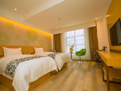 a hotel room with two beds and a flat screen tv at GreenTree Inn Tongchuan Yaozhou District New District Hospital Business Hotel in Yaozhou