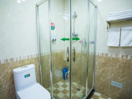 a bathroom with a glass shower with a toilet at Green Alliance Langfang Xianghe County Xiushui Street PengDa furniture city Hotel in Langfang