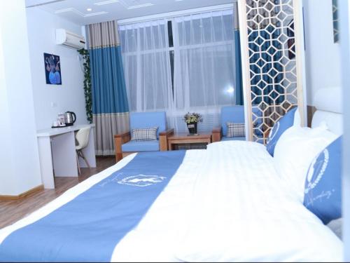 a bedroom with a large bed with a blue blanket at Shell Chengde Longhua County Xingzhou Road Hotel in Chengde