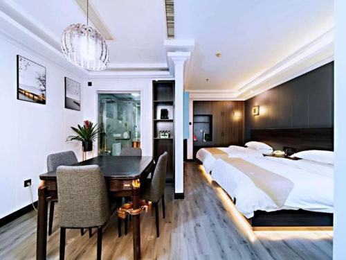 een slaapkamer met een bed en een bureau en een eetkamer bij GreenTree Alliance JiangXi ShangRao YiYang County ZhiMin Aveune YingBin Avenue Hotel in Yiyang