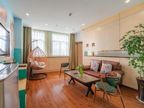 a living room with a couch and a table at Vatica AnHui HeFei Economic Development Zone Hefei University of Technology North Gate Hotel in Ershilipu