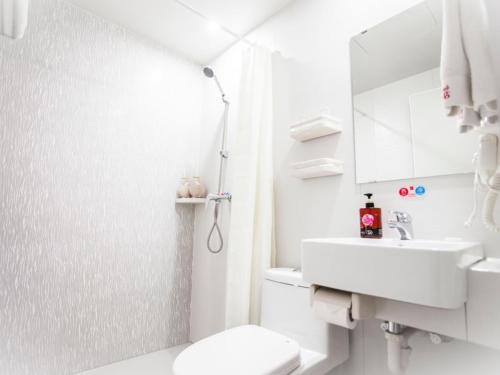 a white bathroom with a toilet and a sink at Shell Taiyuan City Xiaodian District Kangning Street Foxconn Hotel in Taiyuan