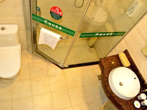 a bathroom with a toilet and a glass shower at GreenTree Inn Shandong Qingdao Jiaozhou Bus Terminal Station Hai'er Avenue Express Hotel in Jiaozhou