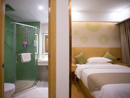 a bedroom with a bed and a bathroom with a shower at GreenTree Inn Huai Nan Shou County Zijin Road Express Hotel in Majiaxu