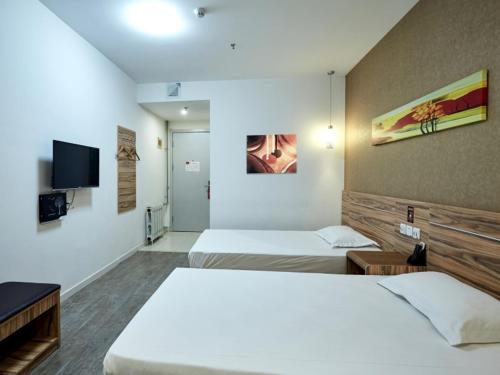 Un pat sau paturi într-o cameră la Shell Yantai Youth South Road Ludong University Hotel