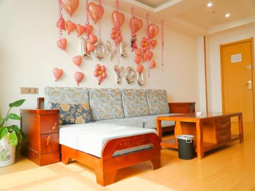 a living room with a couch and balloons on the wall at GreenTree Inn Shijiazhuang Qiaoxi District Zhongshan Road Xili Street Express Hotel in Shijiazhuang