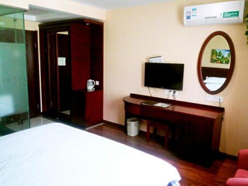 a bedroom with a bed and a desk and a mirror at GreenTree Inn Anhui Chuzhou International Market Place Express Hotel in Chuzhou