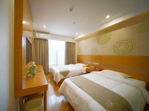 a hotel room with two beds and a window at GreenTree Inn ShanghaiBaoshan District Tieshan Road Youyi Road Hotel in Baoshan