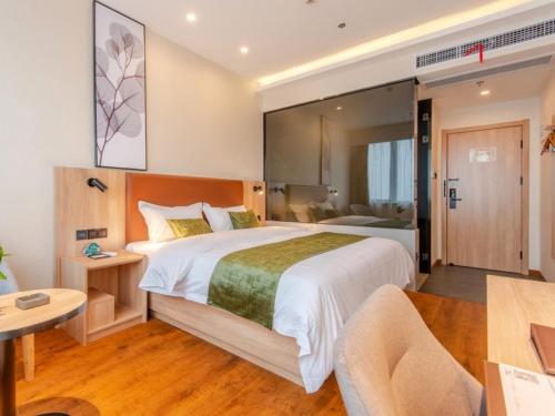 a hotel room with a large bed and a desk at GreenTree Inn Hefei Changjiang West Road Zhenxing Road Subway Station Jiaqiao Yueshan International Business Hotel in Hefei