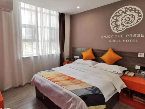 um quarto com uma cama com uma placa na parede em Shell Hefei Yaohai Distrct Baida Zhougudui Daxing RoadHotel em Hefei