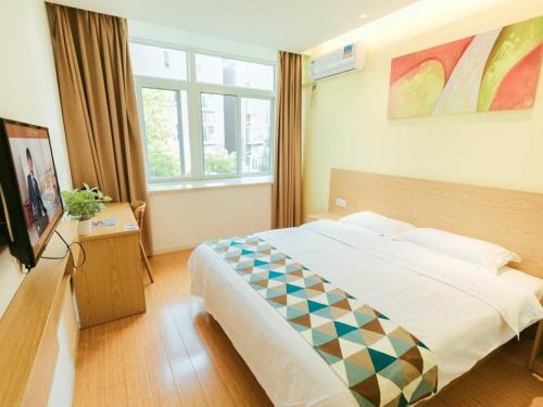 a hotel room with a bed and a window at Shell Shanghai Jiadingbei Subway Station Shuping Road Hotel in Xuhang