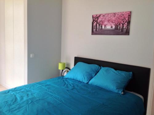 a bedroom with a blue bed with a picture on the wall at Holiday Home t' Keerske in Bruges
