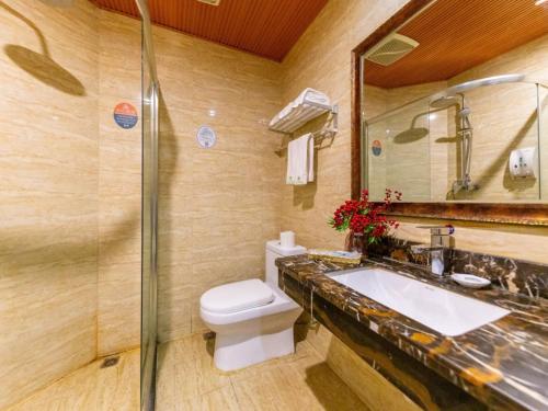 a bathroom with a toilet and a sink and a mirror at GreenTree Inn Lanzhou Railway Station East Road Business Hotel in Lanzhou