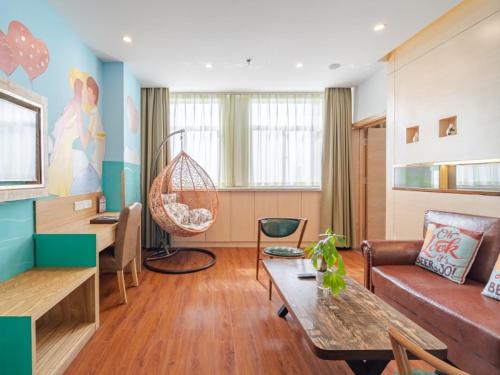 a living room with a couch and a table at Vatica AnHui HeFei Economic Development Zone Hefei University of Technology North Gate Hotel in Ershilipu