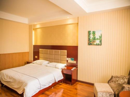 um quarto com uma cama, uma mesa e uma cadeira em GreenTree Inn Jiayuguan Xinhua South Road Express Hotel em Jiayuguan