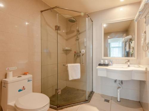 a bathroom with a shower and a toilet and a sink at GreenTree Inn LiuAn Huoshan County Yingjia Avenue County Hospital Express Hotel in Huoshan