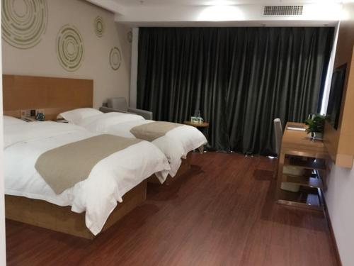 a bedroom with two beds with white pillows at GreenTree Inn Nanjing Jiangning District Jiulong Lake Subway Station Express Hotel in Jiangning
