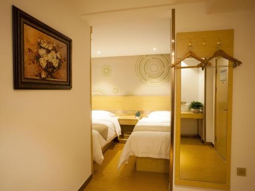 מיטה או מיטות בחדר ב-GreenTree Inn Zhangjiakou City Chicheng County Xiacheng Avenue Oriental Yijing Express Hotel