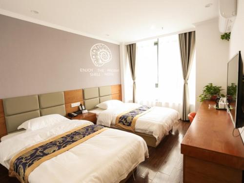 A bed or beds in a room at Shell Hefei Feidong County Baogong Avenue Yulong Mansion Hotel