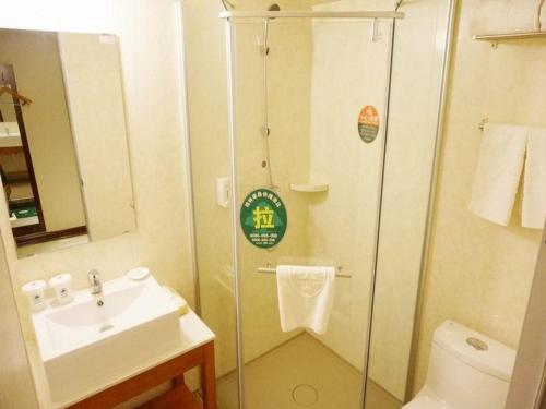 a bathroom with a shower and a sink at GreenTree Inn Shandong Zaozhuang Xuecheng District Road Taishan Road Road Communist Youth League School Express Hotel in Zaozhuang