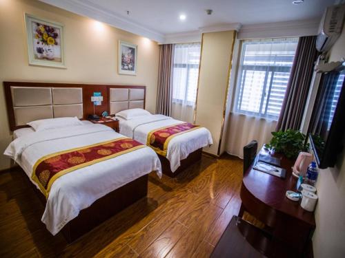a hotel room with two beds and a television at GreenTree Inn Jiangsu Huai’an Hexia Acient Town Zhou Enlai Memorial Hall Express Hotel in Huai'an
