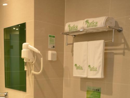 a bathroom with towels hanging on a wall at Vatica Xuzhou Suining Bus Station Bayi West Road Hotel in Suining