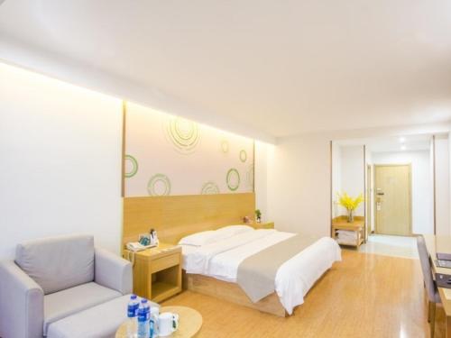 a bedroom with a large white bed and a couch at GreenTree Inn Xingxincheng Town Jiayuan Central Plaza Business Hotel in Jiaxing