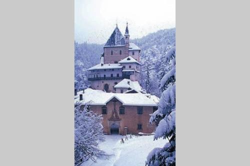 a castle in the mountains covered in snow at Residence Bellavista in Fondo