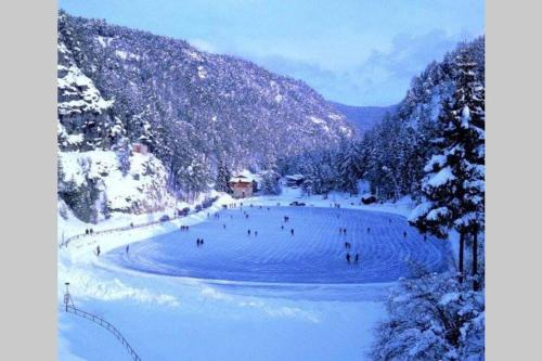 a group of people skiing down a snow covered slope at Residence Bellavista in Fondo