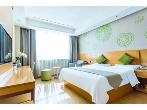 um quarto de hotel com uma cama grande e uma secretária em GreenTree Inn Fuyang Linquan County Economic Development Zone Xingye Road Hotel em Fuyang