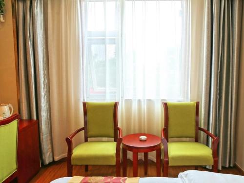 a room with two chairs and a table and a window at GreenTree Inn Wuxi New District Hongshan Town Commercial Square Shell Hotel in Dongkunqiao