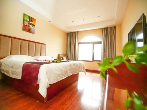 um quarto de hotel com uma cama e uma janela em GreenTree Inn Shandong Qingdao Wuyishan Road Jiashike Shopping center Business Hotel em Huangdao