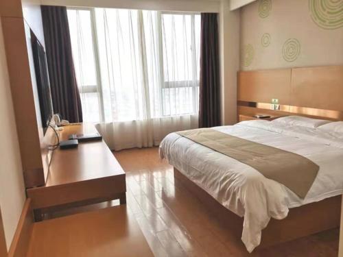 um quarto com uma cama grande e uma secretária em GreenTree Inn Xi'an Gaoling District Handan Industrial Park Express Hotel em Xi'an