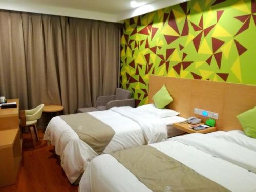 um quarto de hotel com duas camas e uma secretária em Vatica Xuzhou Suining Bus Station Building Materials City Hotel em Suining