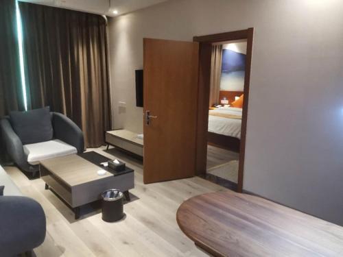 a hotel room with a bed and a chair and a mirror at Shell Liaocheng Linqing City Bus Station Hotel in Liaocheng