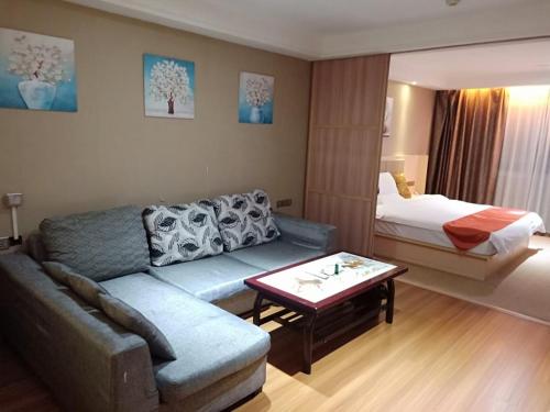 a living room with a couch and a bed at Shell Putian Hanjiang District Hanhua West Road Hotel in Putian