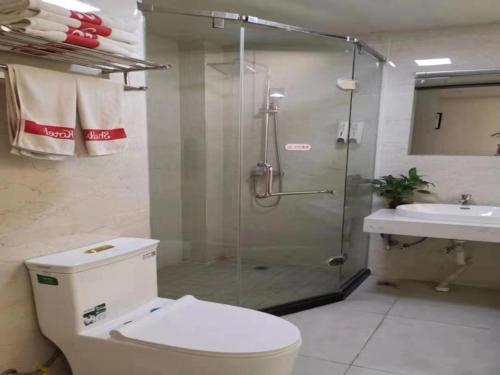 a bathroom with a shower and a toilet and a sink at Shell Lianyungang Donghai County Crystal City Shichen Road Hotel in Donghai