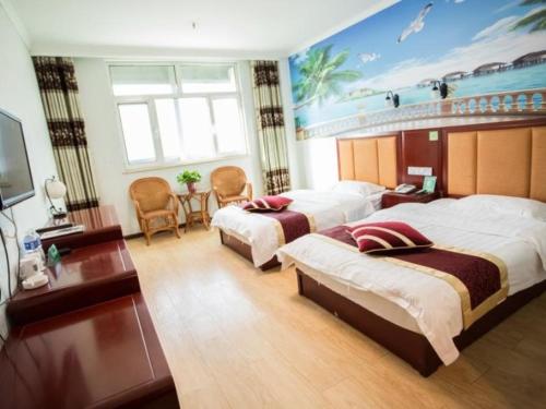 Habitación de hotel con 2 camas y TV en Green Alliance Langfang Xianghe County Xiushui Street PengDa furniture city Hotel, en Langfang