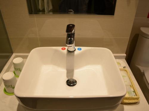 a bathroom sink with a faucet on top of it at Vatica Xuzhou Suining Bus Station Bayi West Road Hotel in Suining