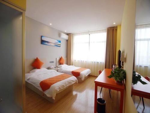 um quarto de hotel com duas camas e uma janela em Shell Nanjing City Qixia District Baguazhou Hotel em Nanquim