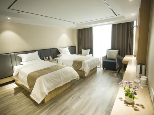 una habitación de hotel con 2 camas y una silla en Shell Xuzhou Suining County Bali Electrical and Mechanical City Hotel en Sui-ning-hsien