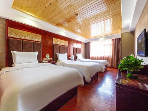 a row of beds in a hotel room at GreenTree Inn Lanzhou Railway Station East Road Business Hotel in Lanzhou