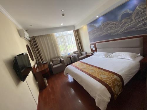 a hotel room with a bed and a television at GreenTree ShangHai JinShan Wanda Plaza Longxiang Road Express Hotel in Jinshan