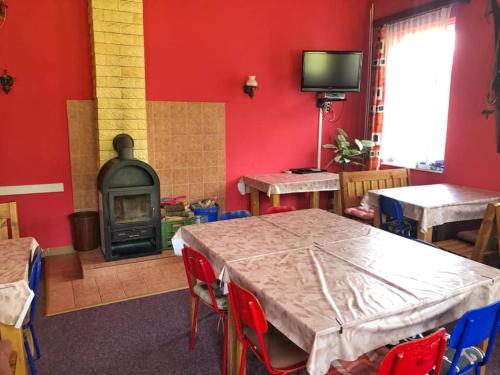 chata Švýcarský dvůr في جانسك لازني: غرفة حمراء مع طاولة ومدفأة