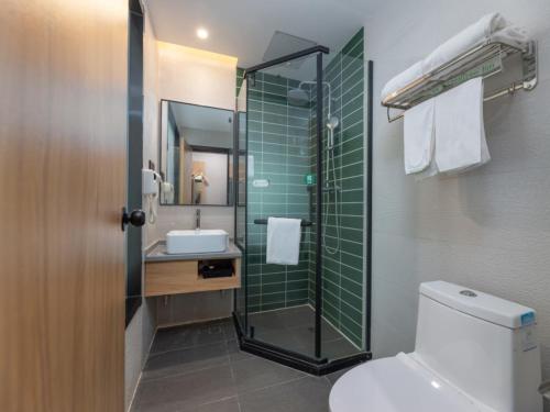 a bathroom with a toilet and a sink and a shower at GreenTree Inn Suzhou Railway Station Park Road Hotel in Suzhou