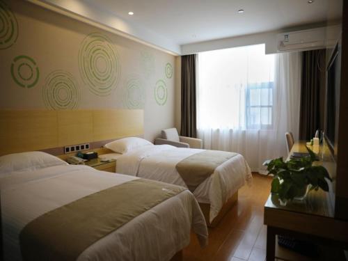 ein Hotelzimmer mit 2 Betten und einem Fenster in der Unterkunft GreenTree Inn Hefei Economic Development Zone Qingtan Road One six eight Middle SchoolExpress Hotel in Hefei