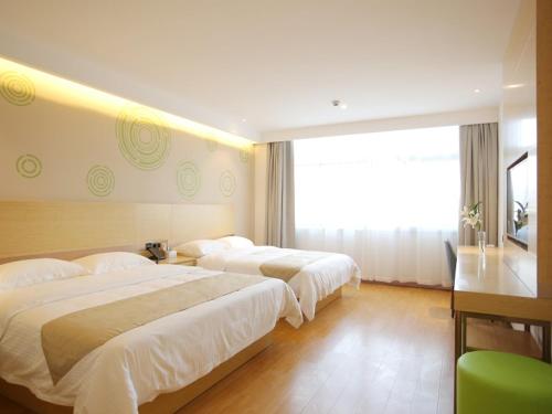 GreenTree Inn Zaozhuang Xuecheng Qilianshan Road Business Hotel tesisinde bir odada yatak veya yataklar