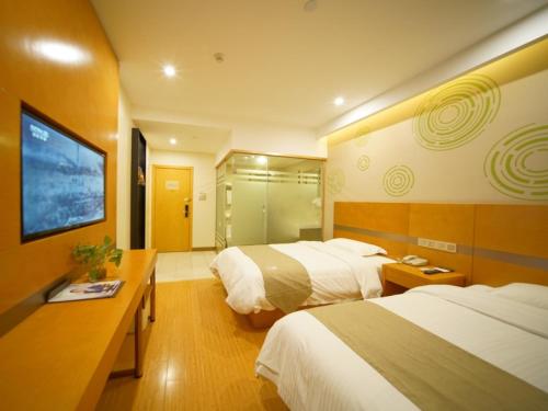 a hotel room with two beds and a television at GreenTree Inn ShanghaiBaoshan District Tieshan Road Youyi Road Hotel in Baoshan